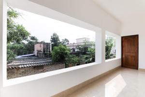 Habitación blanca vacía con vistas desde una ventana en OYO Flagship Sunshine 2 en Khandagiri