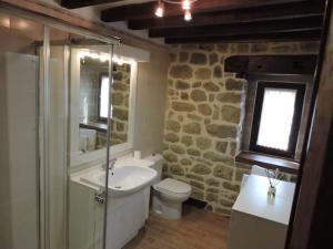 a bathroom with a sink and a toilet and a window at Casa rural La Bárcena Saja in Saja