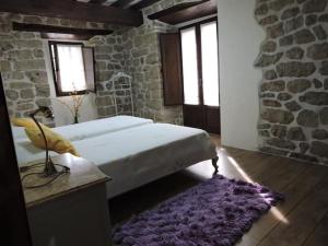 1 dormitorio con cama y alfombra morada en Casa rural La Bárcena Saja, 