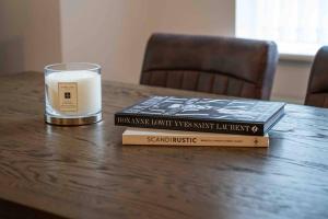 dwie książki siedzące na stole ze świecą w obiekcie Spacious Apartment, Near Birmingham Centre + NEC w Birmingham