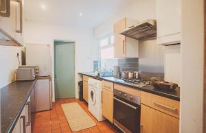 cocina con fregadero y fogones horno superior en Equipped 5bed 2bath House in Coventry City FREE PARKING AMENITIES ROADLINKS WI-FI SMART TV en Coventry