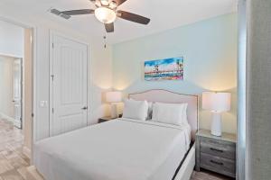 een slaapkamer met een wit bed en een plafondventilator bij 2959 Castaway Lane in Orlando