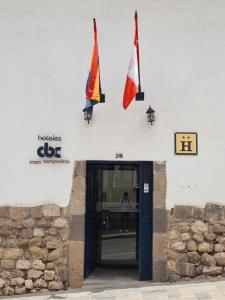 dos banderas a un lado de un edificio en Hotel Casa Campesina en Cuzco