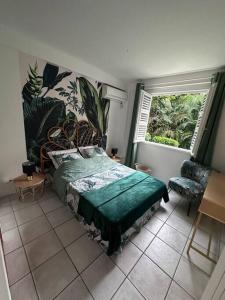 a bedroom with a green bed and a window at La Kaz à MaLou appartement de standing avec piscine et plage à 800m in Les Trois-Îlets +17 photos