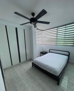 1 dormitorio con 1 cama y ventilador de techo en Departamento bonito y comodo en Tonsupa, en Tonsupa