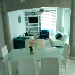 een woonkamer met een witte tafel en stoelen bij Departamento bonito y comodo en Tonsupa in Tonsupa