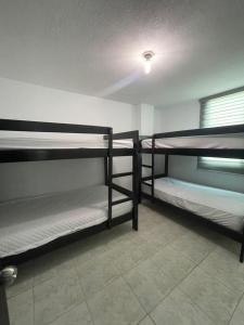 three bunk beds in a room with a window at Departamento bonito y comodo en Tonsupa in Tonsupa