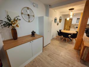 una cucina e un soggiorno con tavolo e orologio di Apartamentos Santander 2 a Santander