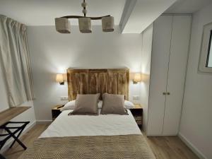 una camera con letto e testiera in legno di Apartamentos Santander 2 a Santander