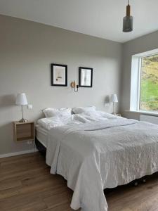 a white bedroom with a bed and a window at Beautiful house with an outstanding view in Hvolsvöllur