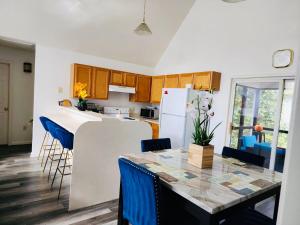 uma cozinha e sala de jantar com uma mesa e cadeiras azuis em Mountain Royal at the Woods Resort em Hedgesville