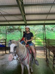 Una donna è seduta su un cavallo di Palm Beach Inn a Playa Grande