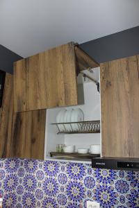 uma cozinha com armários de madeira e azulejos azuis e brancos em MIRAMEL HOME Centro em Yakkasaray