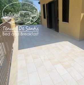 a tile patio with a gate and a fence at Tenuta De Santis in Ceccano