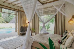 a bedroom with a canopy bed and a pool at Zanzi Resort in Zanzibar City