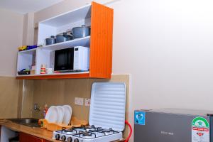 a kitchen with a stove and a microwave at Elly Residence in Nairobi