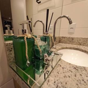 a bathroom counter with a sink and two faucets at Apartamento - Batel/Água Verde - Shopping Curitiba in Curitiba