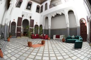 a lobby with couches and potted plants in a building at hostel Dar belghiti in Fez