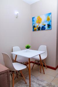 a white table and chairs in a room at Elly Residence in Nairobi