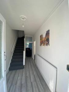 a hallway with a staircase in a house at London Recently Refurbished House in Thornton Heath