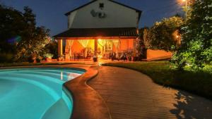- une piscine en face d'une maison la nuit dans l'établissement Apartment Nona Ančka, à Marezige