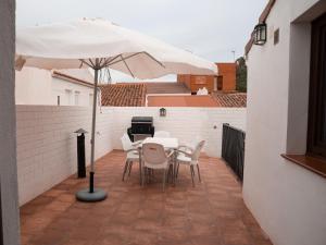 un patio con mesa, sillas y sombrilla en Casa Rural El Palomeque, 