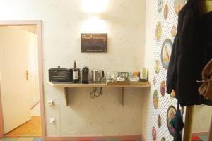 a room with a shelf on the wall with a microwave at Nobel-Prize-Appartement in Graz