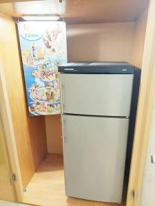 a small white refrigerator in a room with a sign at Nobel-Prize-Appartement in Graz