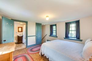 een slaapkamer met een bed en een badkamer met een wastafel bij Jim Croces Farmhouse Apartment in Downingtown! in Downingtown