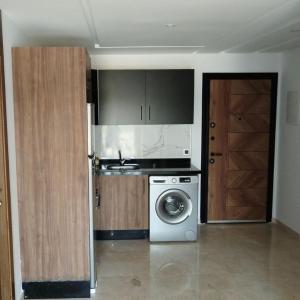 a kitchen with a washing machine and a door at Studio Haut Standing à 150m de Hopital Cheikh Zayed Casablanca, lotissement Majorelle lot 87 Hay Hassani in Casablanca