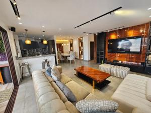 a living room with a couch and a tv at Lujoso PH con JACUZZY Privado in Guayaquil