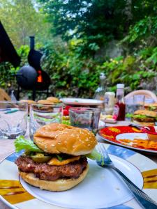 a hamburger on a plate on a table at Cozy Cabin in the Woods in Brezovica