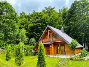 uma cabana de madeira no meio de um campo com árvores em Cozy Cabin in the Woods em Brezovicë