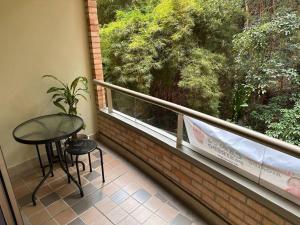 d'un balcon avec une table, deux chaises et une fenêtre. dans l'établissement Torre Colibrí, à Sabaneta