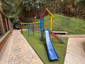 une aire de jeux avec des équipements colorés sur une pelouse dans l'établissement Torre Colibrí, à Sabaneta