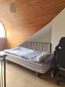 a bed in a room with a wooden ceiling at Glasgow City in Glasgow