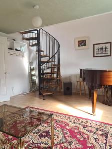 a living room with a spiral staircase and a piano at Glasgow City in Glasgow