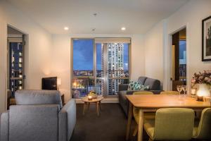 een woonkamer met een bank en een tafel bij Barclay Suites in Auckland