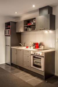 a kitchen with a stove and a refrigerator at Barclay Suites in Auckland