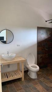 uma casa de banho com um lavatório, um WC e um espelho. em Casa Paz em Parrita