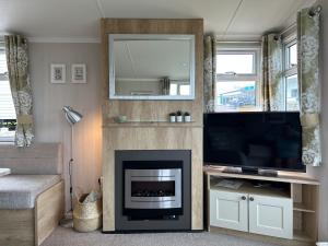 a living room with a fireplace and a flat screen tv at High View in Torquay