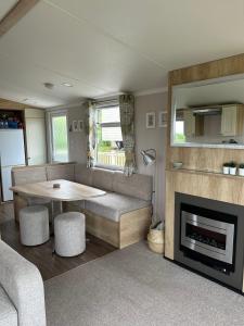 uma sala de estar com um sofá, uma mesa e uma lareira em High View em Torquay