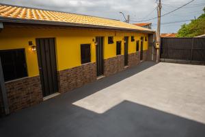 a yellow house with a large driveway at Hotel Nixon Próximo, Rodoviária, Prefeitura e a Matriz central in Itaí