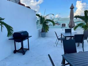 - un barbecue sur une terrasse avec des tables et des chaises dans l'établissement MAYAB Playa - 5Th. Ave, à Playa del Carmen
