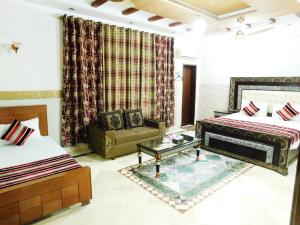 ein Wohnzimmer mit 2 Betten und einem Sofa in der Unterkunft Moon Palace Hotel Lahore in Lahore