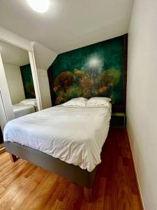 een slaapkamer met een bed met een schilderij aan de muur bij GREENWOOD CHATOU - 1 chambre - 4 Pers - Wifi in Chatou