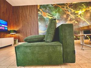 een groene stoel met twee kussens in een kamer bij GREENWOOD CHATOU - 1 chambre - 4 Pers - Wifi in Chatou