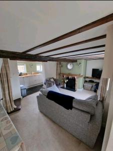 een woonkamer met een bank en een open haard bij Daisy Cottage in Warminster
