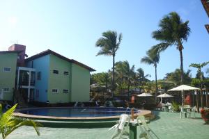 uma piscina num resort com palmeiras em Apto a 300m da praia AxéMoi em Porto Seguro