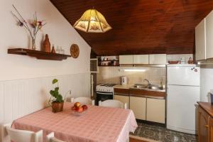 a kitchen with a table and a white refrigerator at Apartment Ikana in Dubrovnik